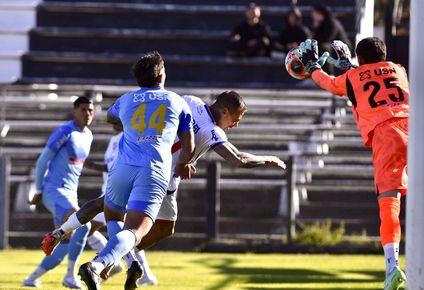 Francisco Tinaglini de Montevideo City Torque se queda con la pelota ante la llegada de Eduardo Vargas de Nacional por el Torneo Intermedio
