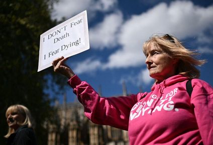 Una activista discapacitada de "Dignity in Dying" sostiene una pancarta durante una concentración a favor de las propuestas para legalizar el suicidio asistido en Reino Unido.