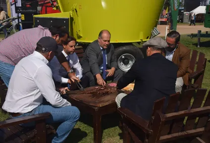 Asado, al costado de un mixer.