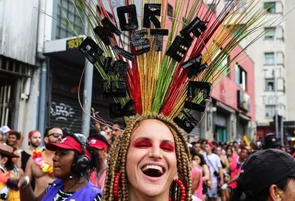 Una de las participantes del carnaval lleva un tocado decorado con la frase amor y resistencia
