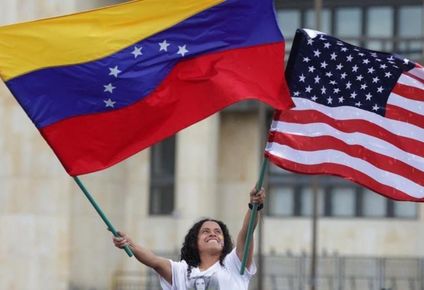 Una mujer ondea las banderas de EE.UU. y Venezuela.
