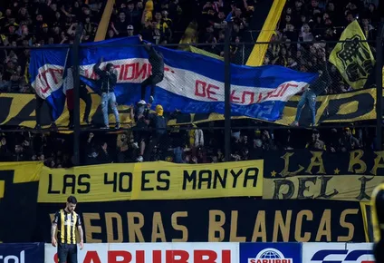 Bandera de Nacional exhibida por la hinchada de Peñarol