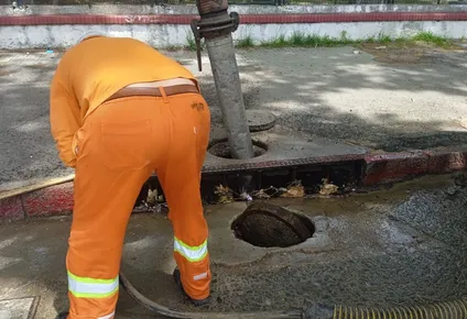 Trabajador municipal limpia boca de tormenta