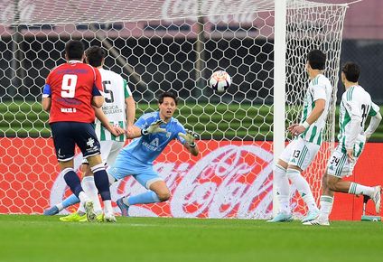 Federico Varese a punto de atrapar el disparo de Maximiliano Gómez en el partido entre Racing y Nacional